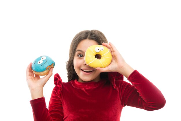 Fille tenir beignet sucré fond blanc Enfant affamé de beignet sucré Niveaux de sucre et nutrition saine Conseils nutritionniste Obsession douce Enfance heureuse et friandises Concept de régime de rupture