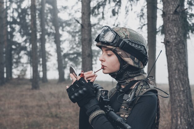 Fille en tenue de camouflage avec une arme