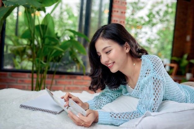 Fille en tenue décontractée écrivant un journal ou étudiant au lit en pensant.