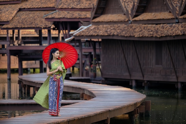 Fille thaïlandaise en costume traditionnel costume parapluie rouge