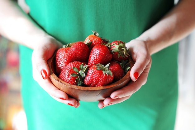 Fille tient une assiette de fraise rouge