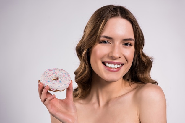 Photo fille tient un beignet dans les mains