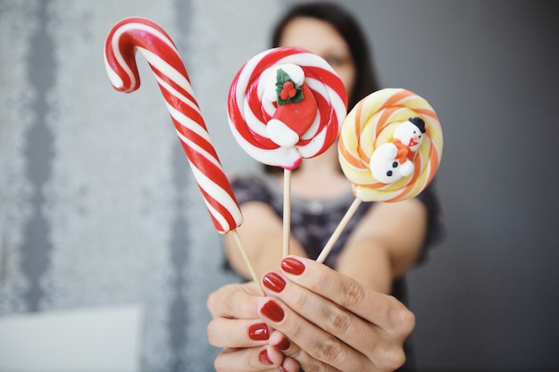 La fille tient des bonbons colorés dans ses mains.