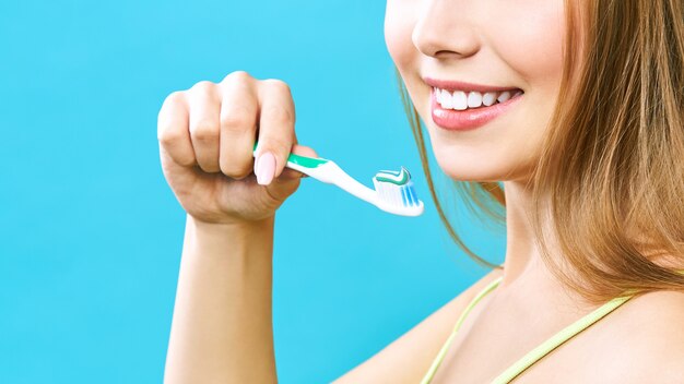 Photo une fille tient une brosse à dents