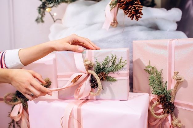 Fille tient un cadeau, arbre de Noël, boîte rose avec un cadeau