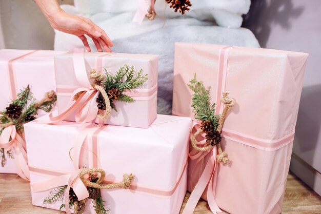 Fille tient un cadeau, arbre de Noël, boîte rose avec un cadeau