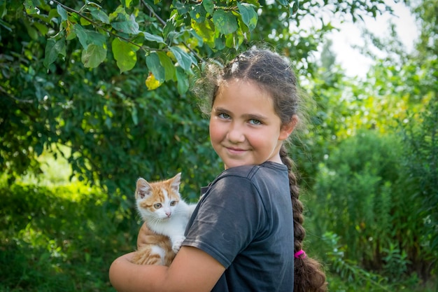 Une fille tient un chat dans ses bras.