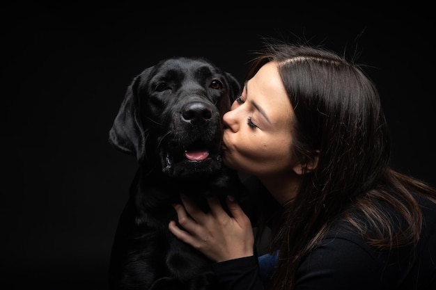 Une fille tient un chien Labrador Retriever dans ses bras