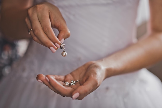 Fille tient dans les mains des boucles d'oreilles 721