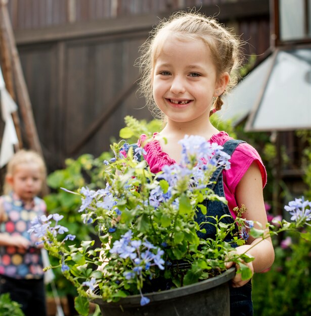 Fille tient une fleur dans un jardin