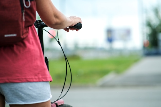 La fille tient le guidon du vélo dans un style magnifique.