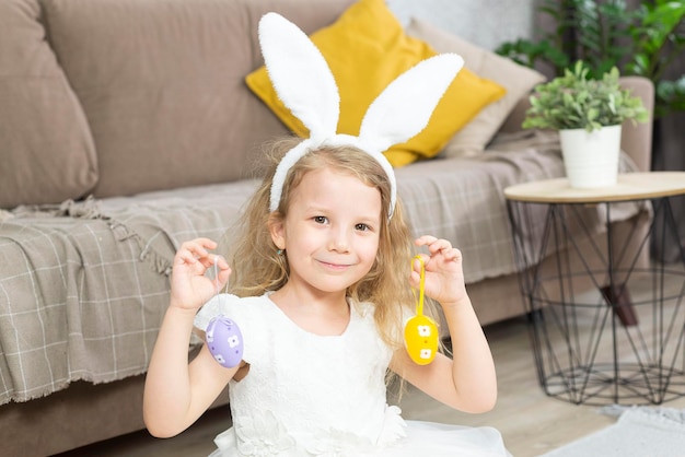 une fille tient des oeufs de pâques et sourit