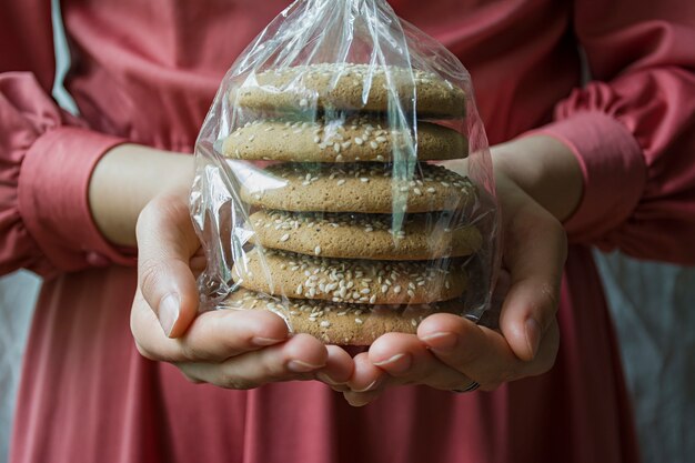 Une fille tient un paquet avec des biscuits à l&#39;avoine.