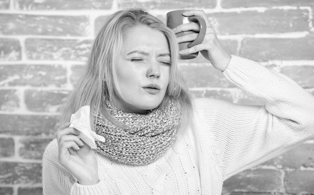 Une fille tient une tasse de thé et un mouchoir Nez qui coule et autres symptômes du rhume Boire beaucoup de liquide est important pour assurer une récupération rapide du froid Boire plus de liquide se débarrasser du rhume Remèdes contre le rhume et la grippe