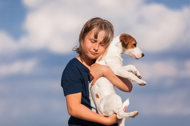 La fille tient le terrier de Jack Russell dans des ses bras