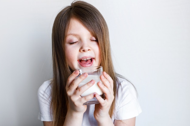 fille tient un verre de lait et apprécie le goût de l'espace pour le texte