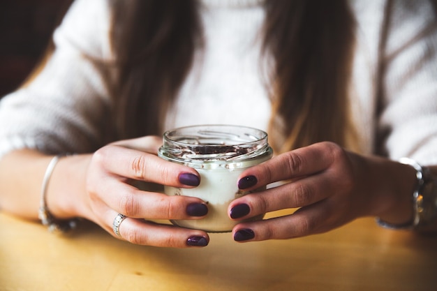 Fille tient un verre de lait ou de yaourt. en mangeant. Copiez l'espace. Petit déjeuner, collation.