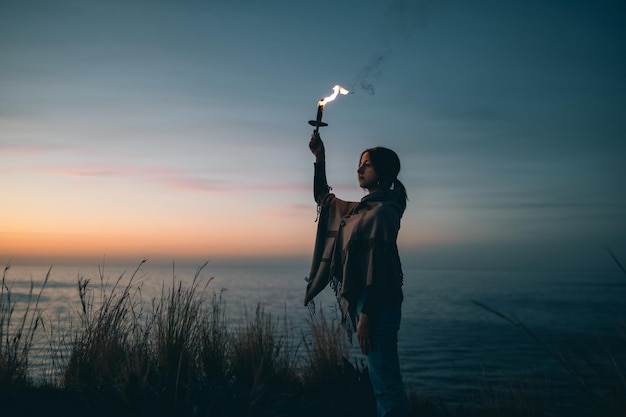 Fille avec torche et bras vers le ciel