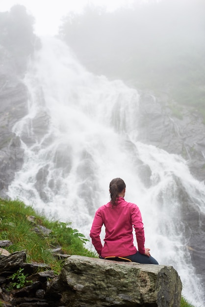 Fille de tourisme détente sur rocher bénéficiant d'une vue magnifique cascade Balea