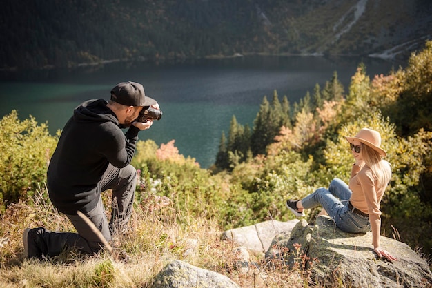 Fille de tourisme posant pour une photo au sommet de la montagne. Photographe prenant des photos d'une jeune fille