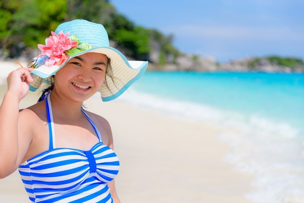 Fille de touriste en maillot de bain rayé blanc bleu pose debout avec bonheur sur la belle plage et la mer pendant l'été à l'île de Koh Miang, parc national de Mu Ko Similan, province de Phang Nga, Thaïlande