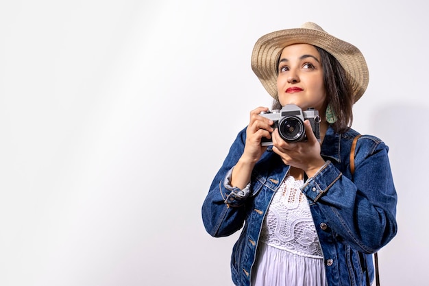 Fille de touristes prenant des photos avec son concept de voyage appareil photo rétro fond blanc