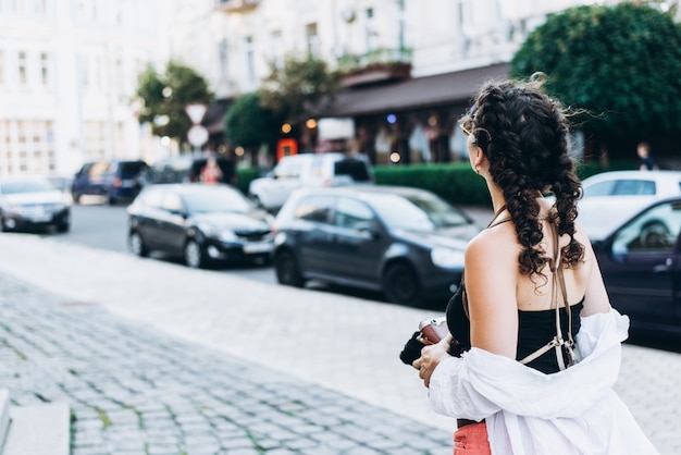 Une fille touristique avec une caméra ancienne