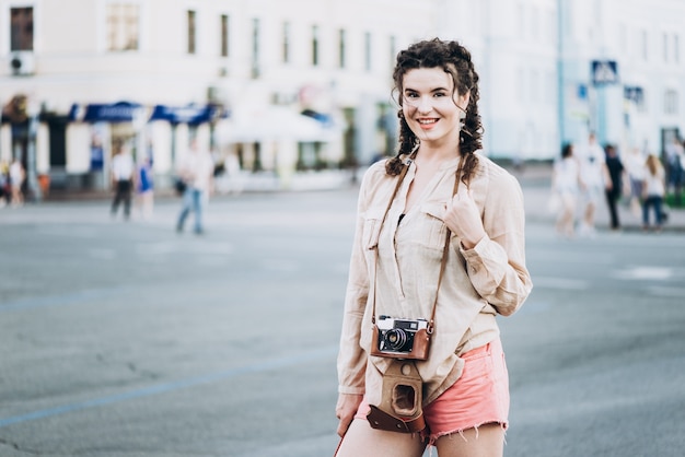 Une fille touristique avec une caméra ancienne