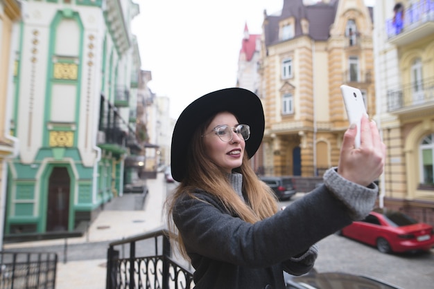 Fille touristique élégante prend selfie