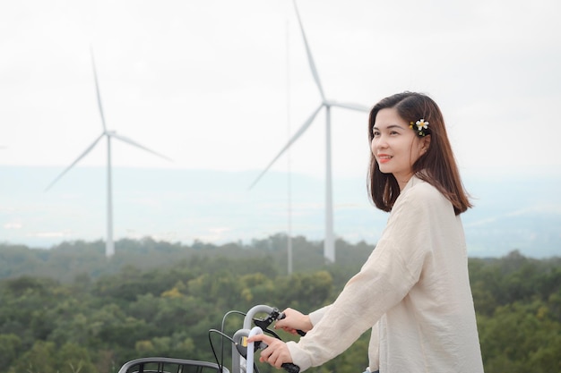 Fille touristique Visitez les champs de moulins à vent à la centrale électrique renouvelable L'arrière-plan est une éolienne produisant de l'électricité sur une belle montagne