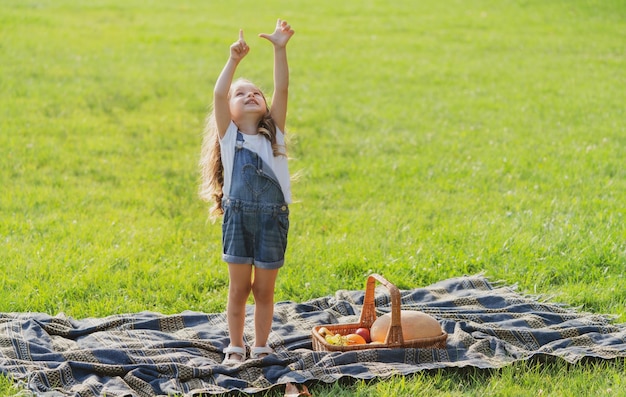 Fille sur tout-petit enfant pique-nique avec panier dans un parc ou un jardin ensoleillé