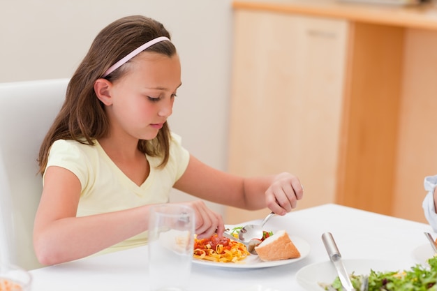 Fille en train de dîner à la table