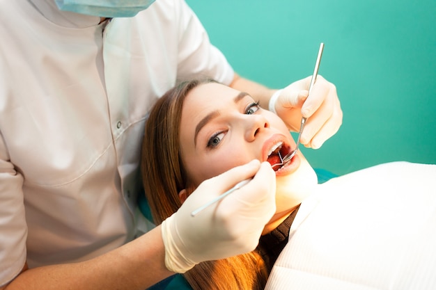 Fille traite les dents chez le dentiste. Gros plan de traitement dentaire