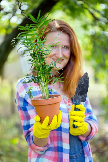 Une fille transplante des fleurs dans le jardin. pots de fleurs et plantes à transplanter