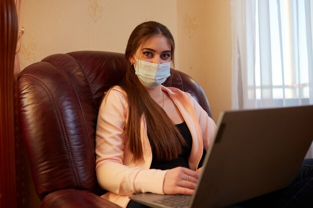 Photo fille travaillant sur un ordinateur portable assis sur une chaise