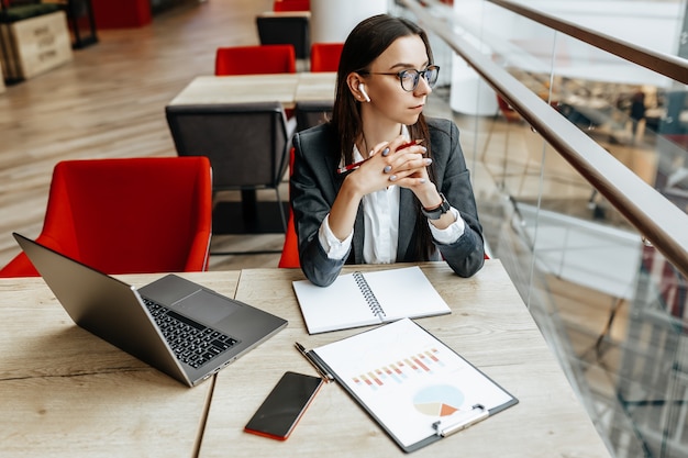 Fille travaille sur un ordinateur portable au bureau