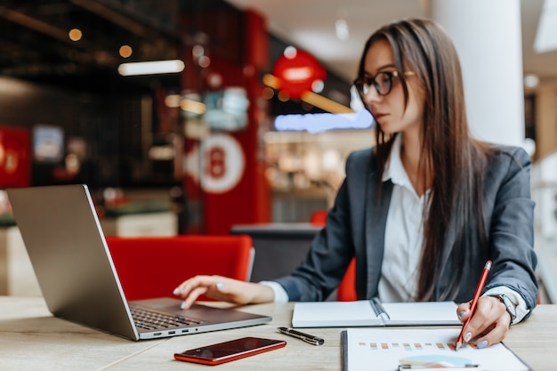 Fille travaille sur un ordinateur portable sur le lieu de travail