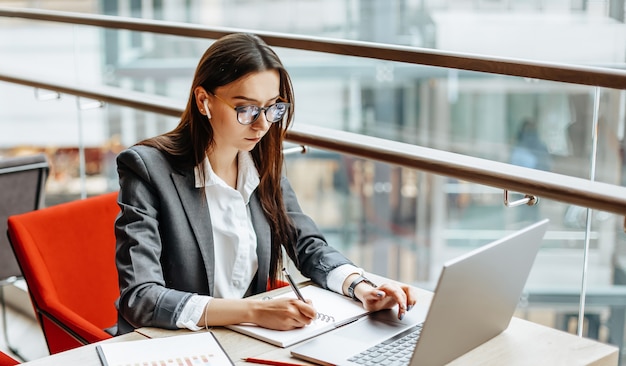 Fille travaille sur un ordinateur portable sur le lieu de travail