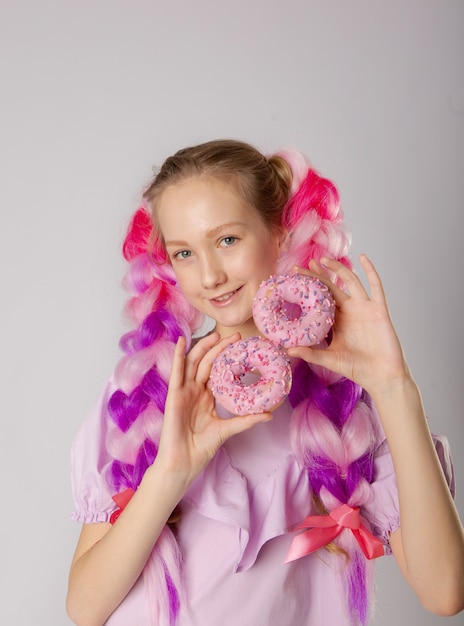 Fille avec des tresses et des beignets colorés