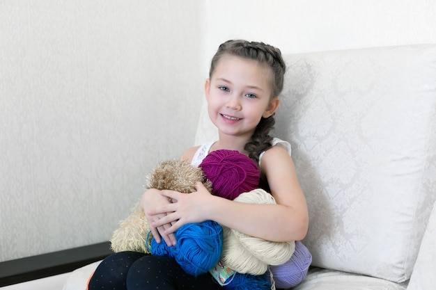 La fille tricote avec du tricot et du fil.