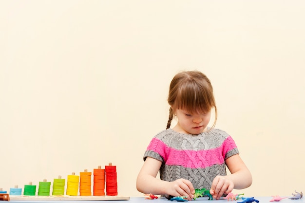 Fille trisomique jouant avec des jouets