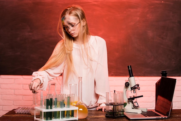 Fille triste bouleversée après avoir fait son expérience chimique dans un laboratoire Explosion dans le laboratoire Science et éducation Petite fille chimiste mélangé de mauvais réactifs