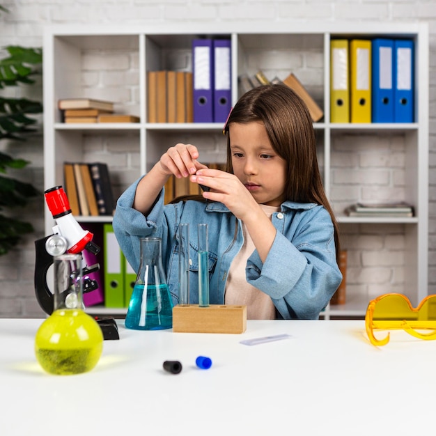 Photo fille avec tubes à essai et microscope