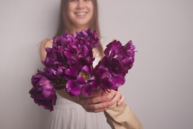 Fille avec des tulipes sur fond blanc