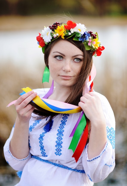 Fille ukrainienne dans une chemise et une couronne de fleurs sur la tête