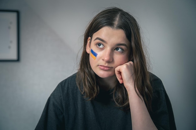 Une fille ukrainienne avec un drapeau peint de l'ukraine sur son visage