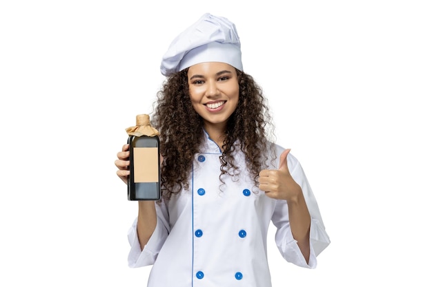 Une fille en uniforme de chef isolé sur fond blanc