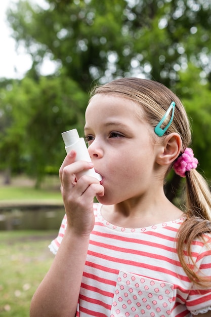 Fille utilisant un inhalateur pour l'asthme