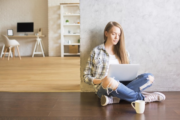 Fille utilisant un ordinateur portable à l'intérieur