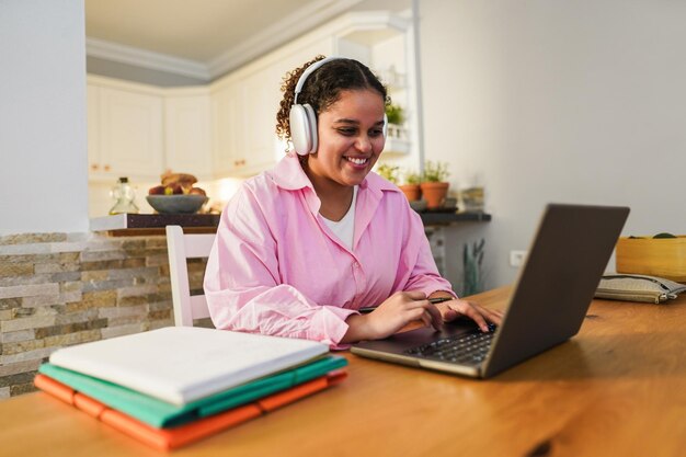 Fille utilisant un ordinateur portable à la maison tout en travaillant sur un projet universitaire Concept scolaire et technologique Se concentrer sur le visage